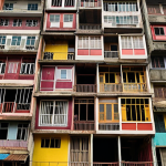 A vibrant, diverse community displaced by modern high-rise buildings, showing a contrast between traditional Vietnamese homes and modern development. Focus on the human element and emotional impact of displacement.